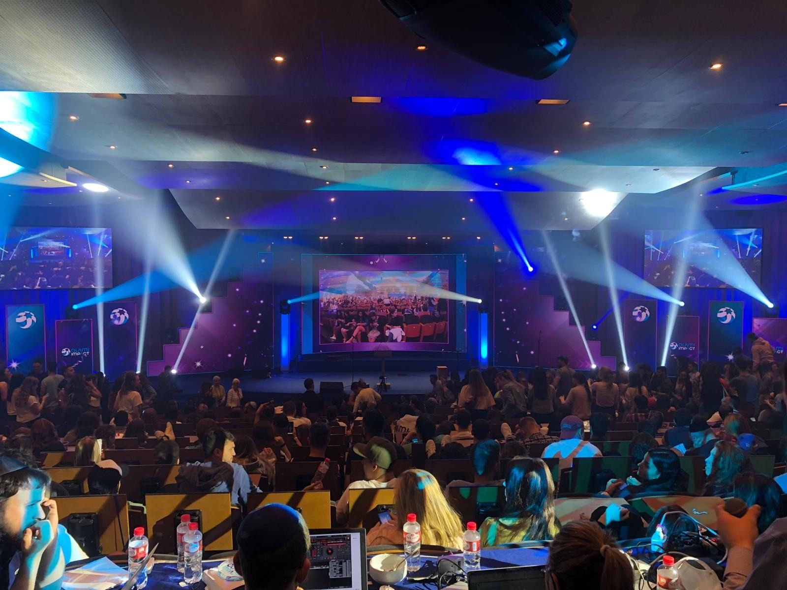 Evento corporativo con pantallas y luces azules
